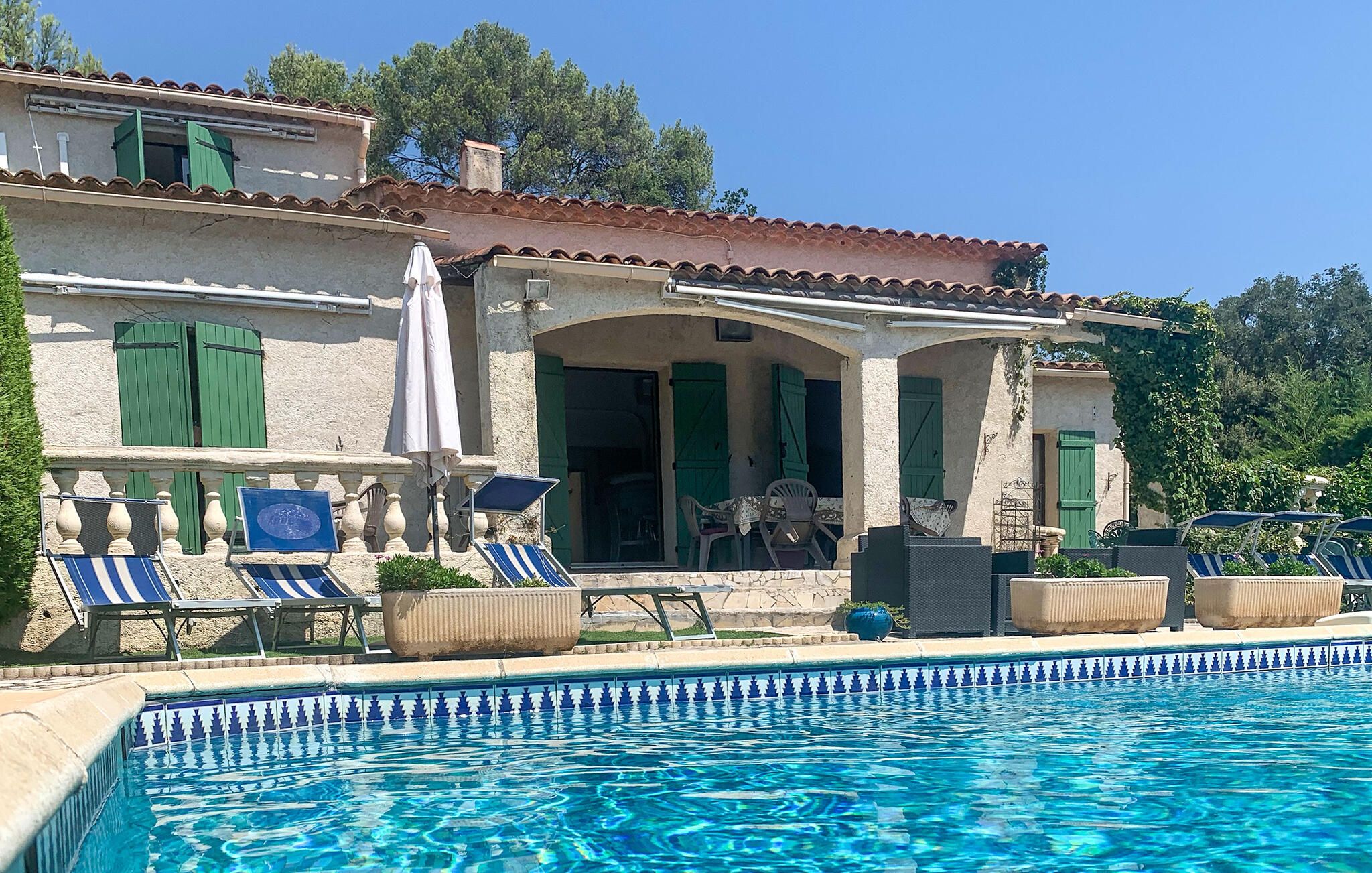 Un espace aménagé au bord de la piscine, avec des chaises longues et une piscine.