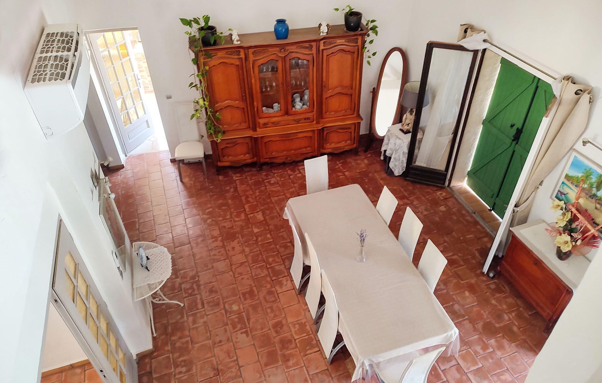 A dining area with a table and chairs, a cabinet with glass doors, and a green door.