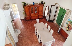 A dining area with a table and chairs, a cabinet with glass doors, and a green door.