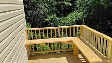 Una terraza de madera con un banco integrado y barandilla.