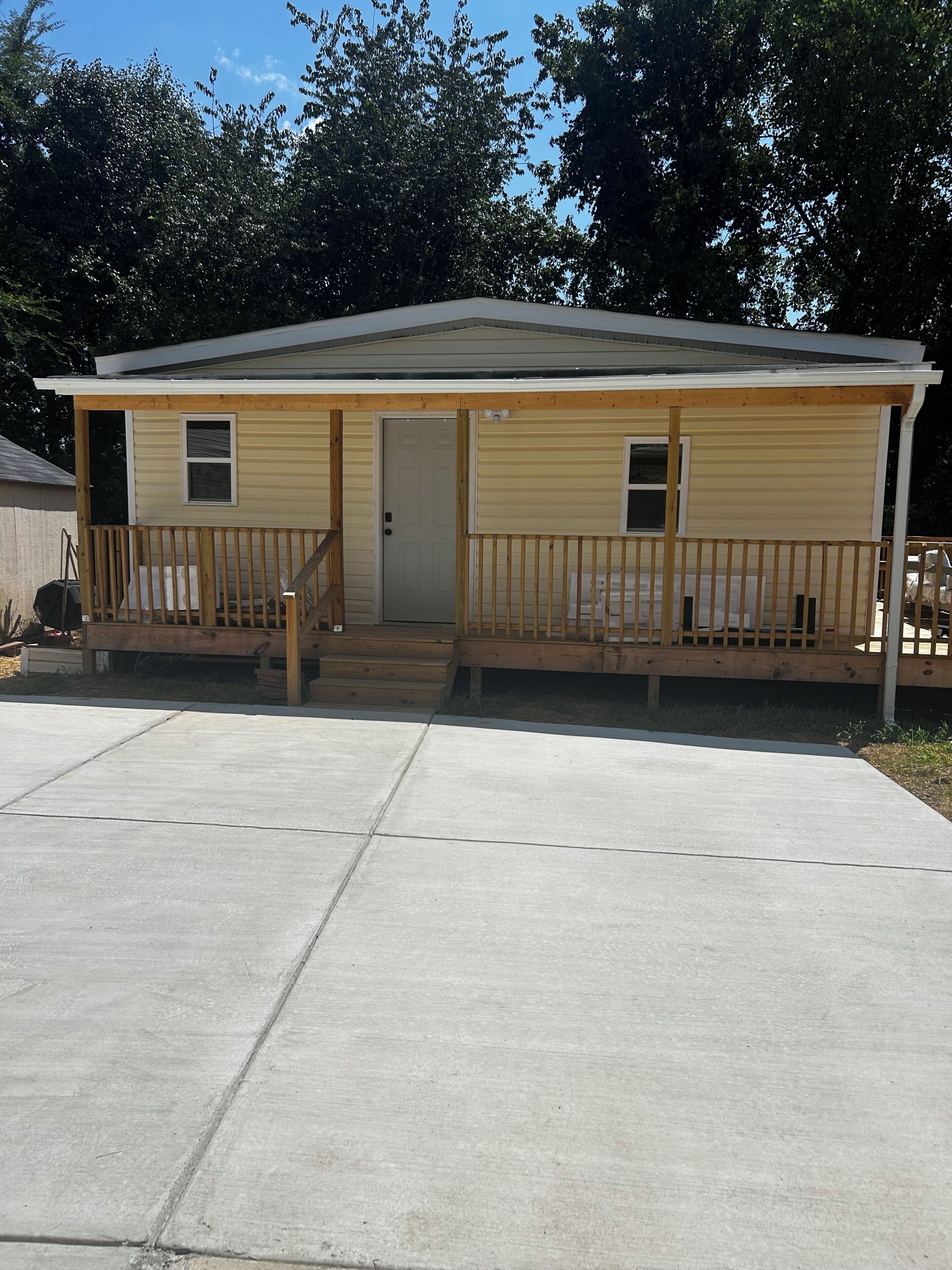 A single-story house with a front porch, a door, and a small attached garage.