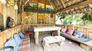 A rustic wooden interior with a bench, pillows, a table, and a bag of firewood. - Gronik Mountain Resort 1 Apartment (Kościelisko)