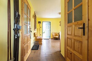 Un pasillo con puertas de madera, un banco y una silla.