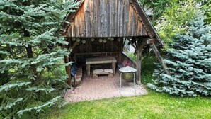 A rustic wooden cabin with a brick patio, a bench, and a table. - Gronik Mountain Resort 1 Apartment (Kościelisko)
