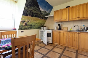 Une cuisine avec des meubles de rangement en bois, une cuisinière, un four à micro-ondes et un évier.