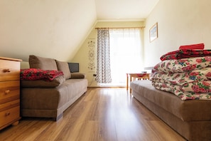 Une petite pièce agréable et chaleureuse, avec deux canapés, une commode en bois et une table.