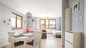 En modern lägenhet med matplats, kök och vardagsrum.