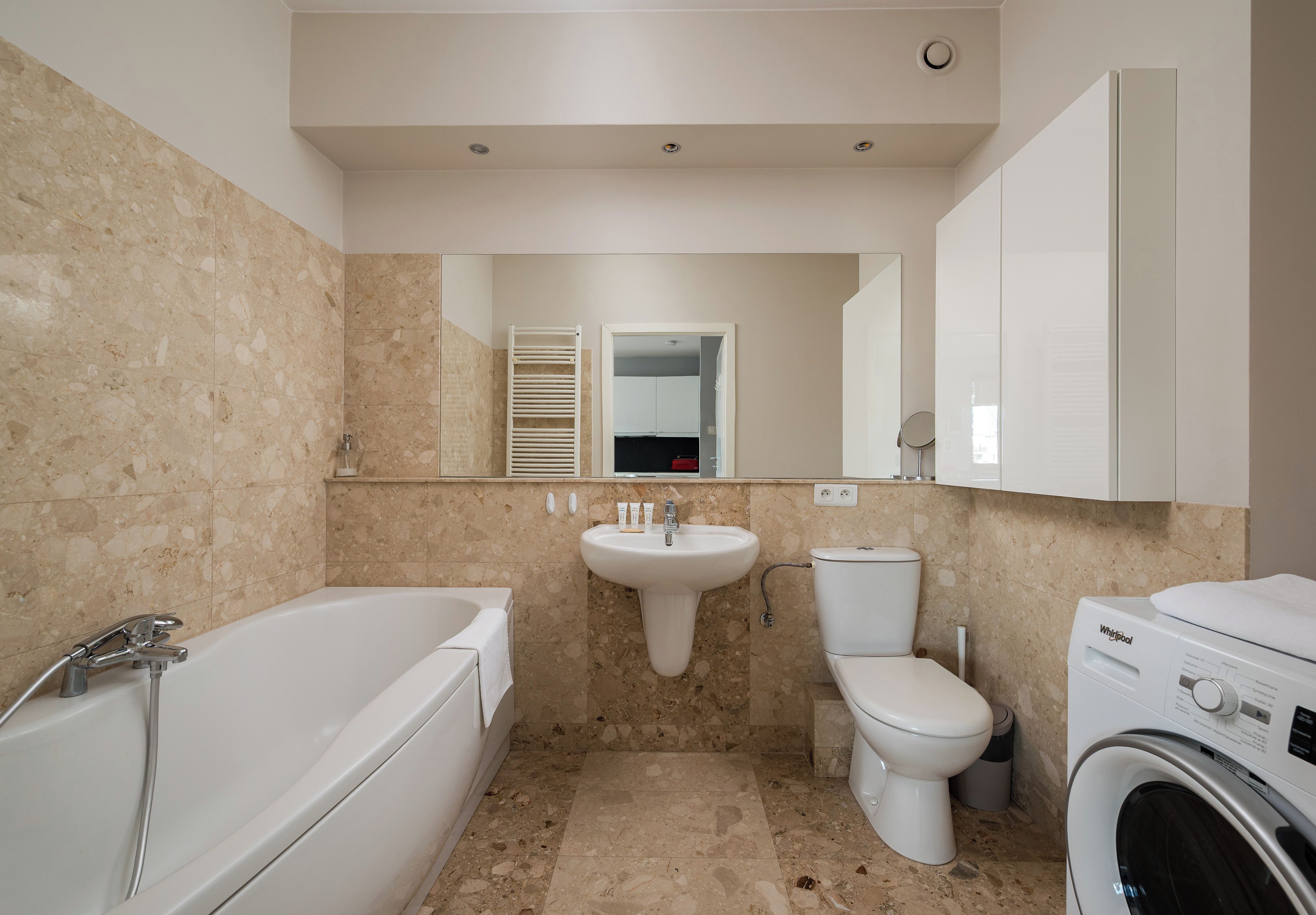 Une salle de bain équipée d’une baignoire, d’un lavabo, de toilettes et d’un lave-linge.