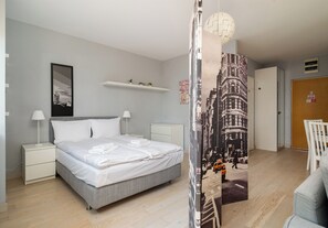 A modern bedroom with a bed, bedside tables, a hanging light fixture, and a cityscape mural on the wall. - Park Praski Charming Apartment (Warszawa)