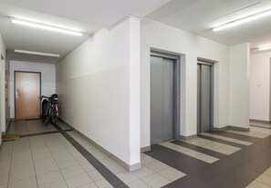 A hallway with two elevators, a door labeled '51', and a bicycle parked against the wall. - Park Praski Charming Apartment (Warszawa)