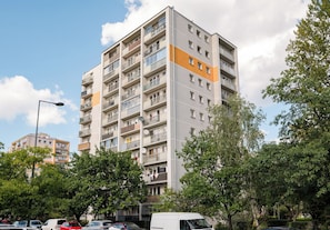 Un edificio residencial de varios pisos con balcones, techo plano y cielo despejado.