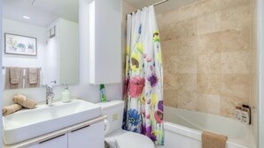 Ein Badezimmer mit einem weißen Waschbecken, Spiegel, WC und Badewanne.