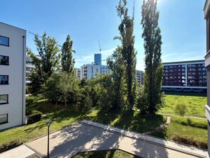 Un quartier résidentiel avec des immeubles modernes, une allée pavée et un terrain herbeux.