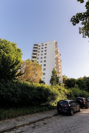 A multi-story residential building with balconies, surrounded by lush greenery and parked cars. - Sopot Peaceful Retreat Apartment (Sopot)