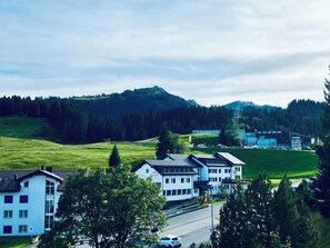 Un hotel de diseño moderno, situado en un valle verde con una montaña al fondo.