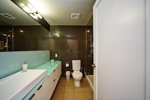 A modern bathroom with a white sink, a toilet, and a glass shower enclosure. - Modern 2 Bedroom Suite Downtown Stay - Near CN Tower & Rogers Centre (Toronto)