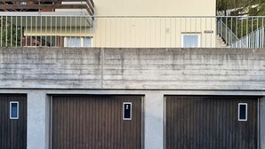A row of three closed wooden doors, each with a small window and a number plate.