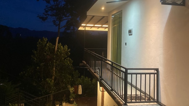 Un edificio con un balcón, una escalera y un ventilador en la pared.