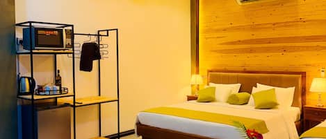 A modern hotel room with a wooden ceiling, a bed with multiple pillows, a small table with a vase, and a built-in air conditioning unit.