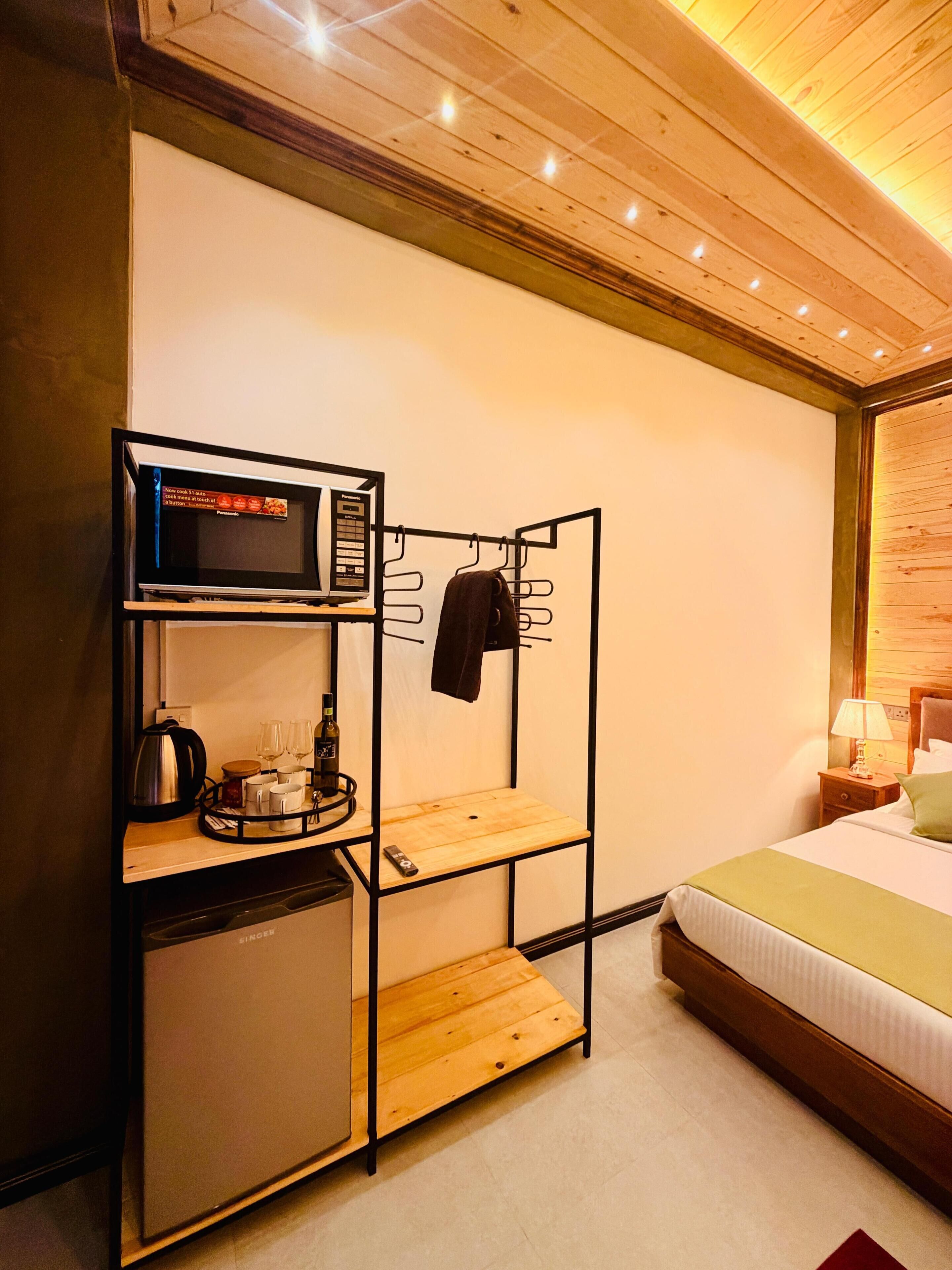 A compact hotel room with a bunk bed, a kitchenette with a microwave, and a small refrigerator.