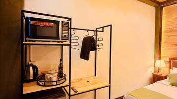 A compact hotel room with a bunk bed, a kitchenette with a microwave, and a small refrigerator.