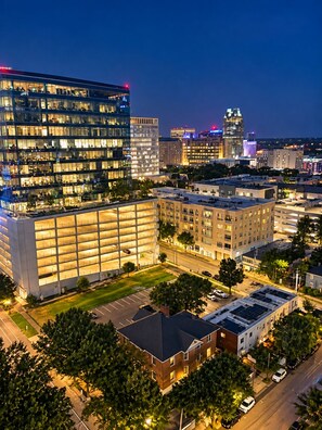A multi-story building with a glass facade and a parking garage. - Downtown Raleigh - Sweeping City Views - Luxury High Floor Unit 2 Bedroom 2 bath (Raleigh)