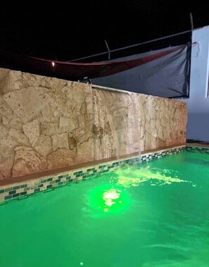 A swimming pool with a stone wall and a tiled border. - Amazing house•Private Pool•Power/Water Backup•Near Airport•Gated Community (San Juan)