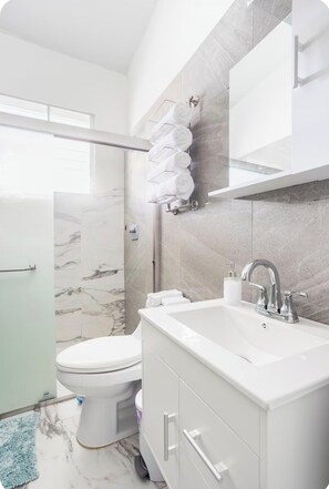 Ein modernes Badezimmer mit Toilette, Waschbecken und Duschbereich.