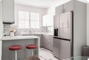 A modern kitchen with a stainless steel refrigerator, a double sink, and a marble backsplash. - Amazing house•Private Pool•Power/Water Backup•Near Airport•Gated Community (San Juan)
