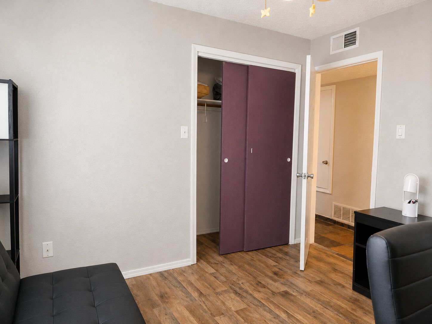 A room with a bed, a wardrobe, and a desk.