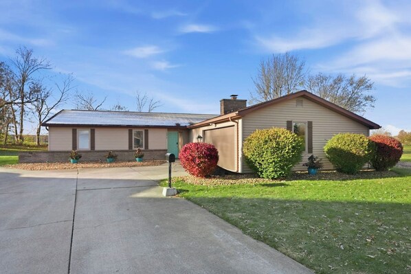 A single-story house with a garage, a front yard with a mailbox, and a clear sky. - Huntertown Haven |3 Bed 3 Ba Ranch Families & Pets (Huntertown)