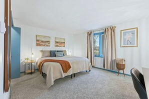 A bedroom with a bed, a bedside table with a lamp, a window with curtains, and a framed picture on the wall. - Huntertown Haven |3 Bed 3 Ba Ranch Families & Pets (Huntertown)