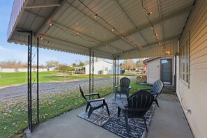 A covered patio with outdoor seating and a view of a residential area. - Huntertown Haven |3 Bed 3 Ba Ranch Families & Pets (Huntertown)