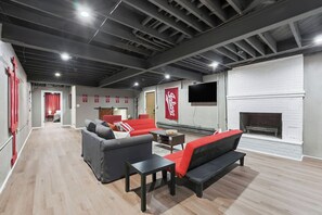 Eine moderne Lounge mit Sofas, Kamin und Fernseher.