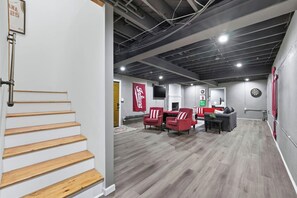 Ein modernes Interieur mit Treppe, Sitzgelegenheit und Dartscheibe.