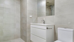Ein Badezimmer mit Dusche, Waschbecken und Toilette.