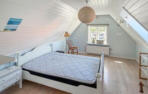Ein Schlafzimmer mit Bett, Stuhl, Schreibtisch und einem Fenster mit Blick.