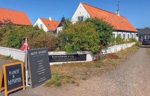 Ein Gebäude mit einem Schild für Kunst & Keramik - Mute Studio, das darauf hinweist, dass hier Workshops, Musik und Meditation angeboten werden.
