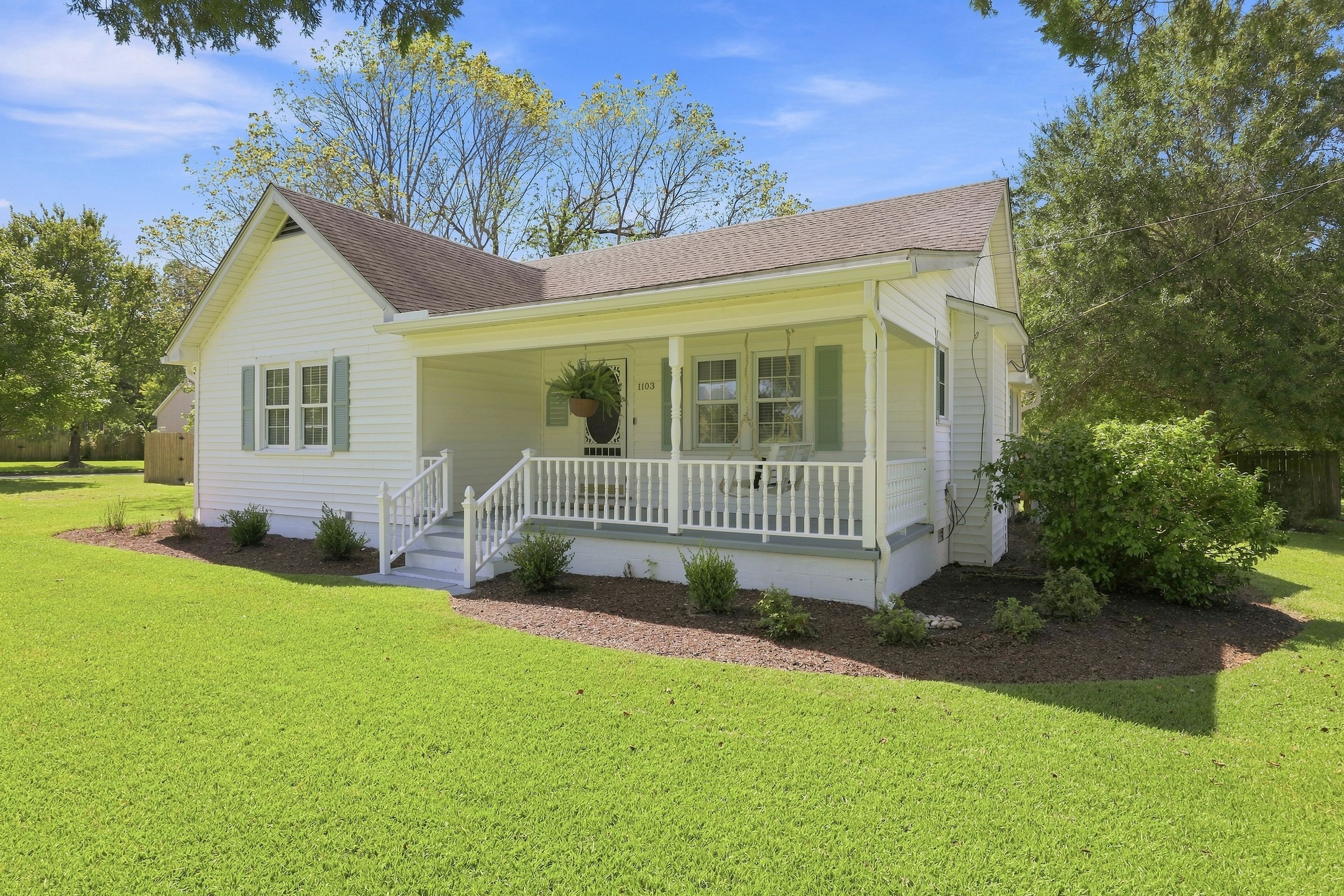 A single-story house with a front porch, a small front yard, and a mailbox.