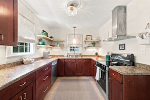 A modern kitchen with granite countertops, wooden cabinets, a stainless steel range hood, and a built-in oven. - Cutest 3 BR cottage in New Bern close to everything! Welcome to the New Bernian! (New Bern)