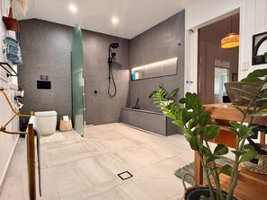 Ein modernes Badezimmer mit einer Duschkabine aus Glas, einer Toilette und einem Waschbecken.