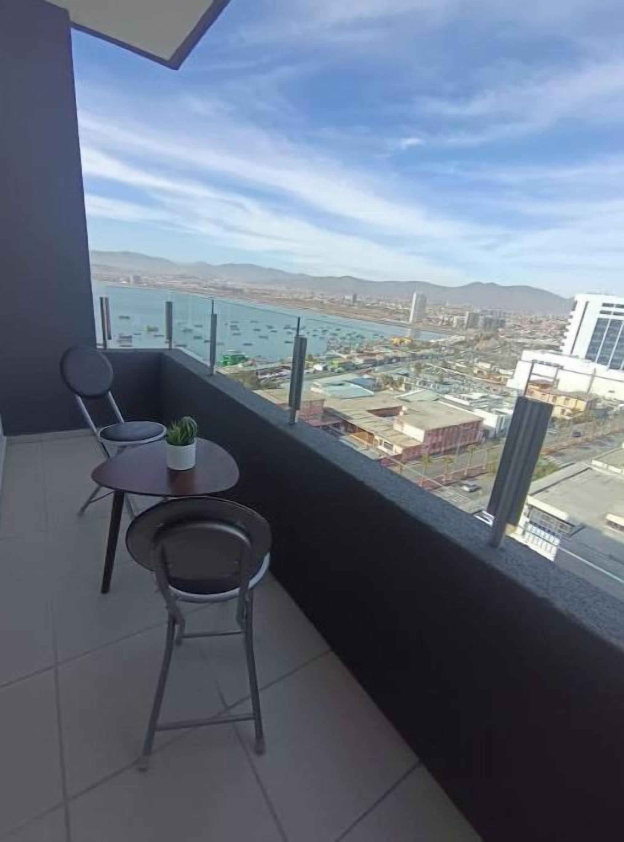 A balcony with a view of a cityscape and water.