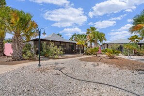 A resort with multiple villas, palm trees, and a gravel driveway. - Casa Divers Dream - Screened porch and shared pool! (Kralendijk)