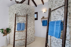 A bathroom with a tiled wall, a wooden ladder, and two towels hanging on hooks. - Casa Divers Dream - Screened porch and shared pool! (Kralendijk)