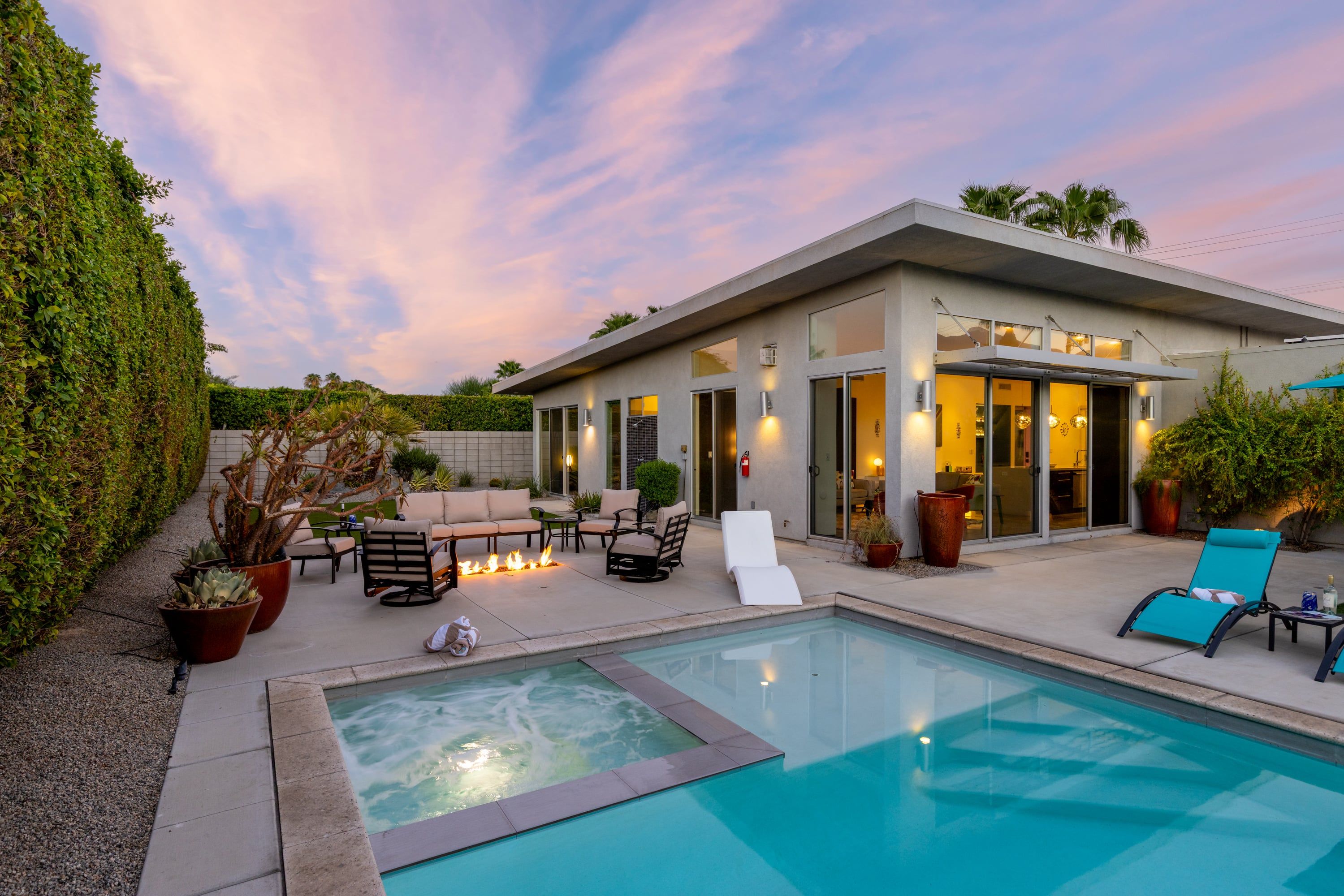 A modern house with a swimming pool, outdoor seating, and a well-maintained garden.
