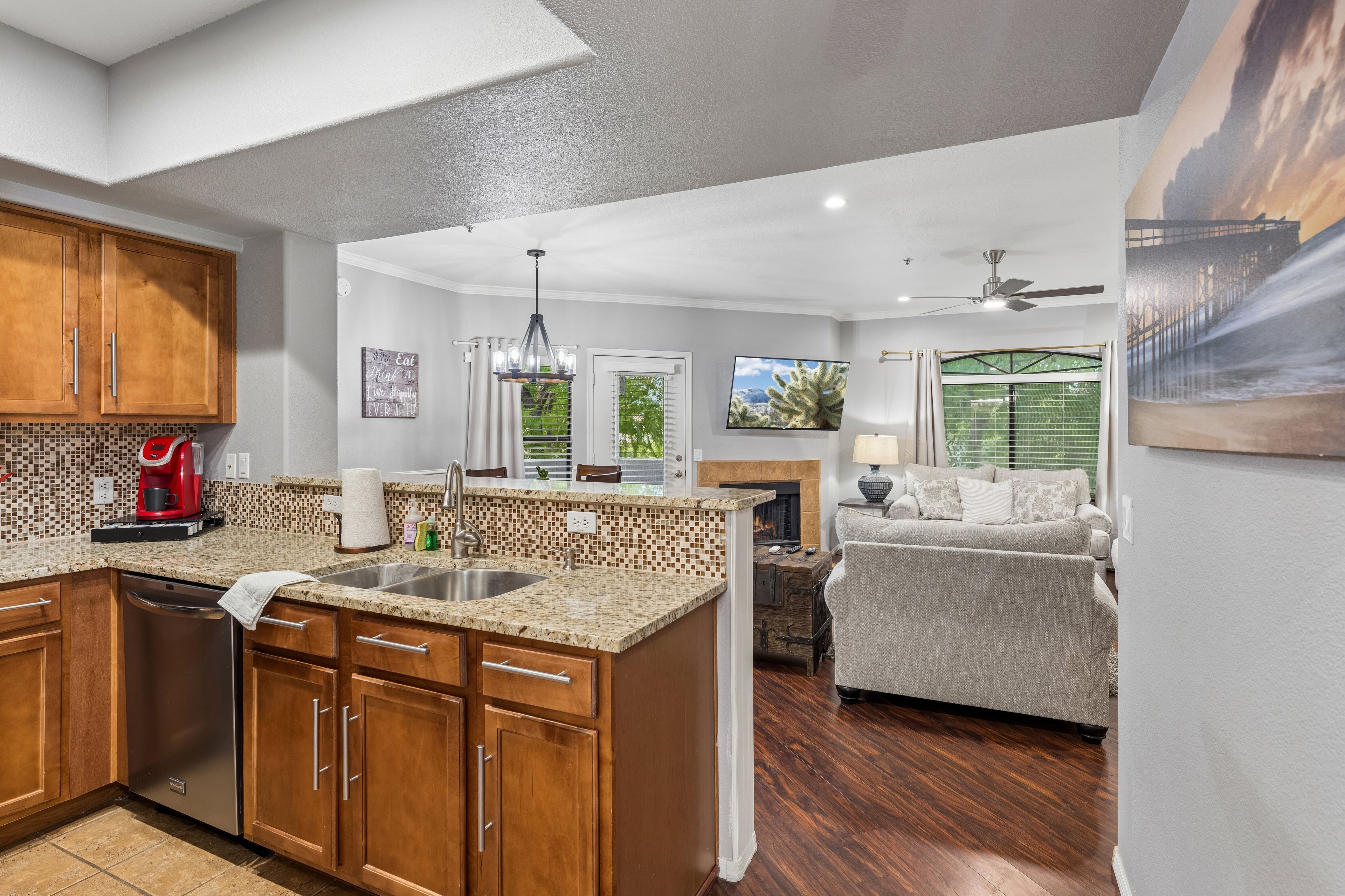 A spacious kitchen with wooden cabinets, a built-in island, and a red coffee maker.