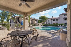 A covered outdoor area with a pool, lounge chairs, and a table. - Horizon Hideaway | Balcony | Pool & Spa | North Scottsdale (Scottsdale)