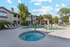 A swimming pool with lounge chairs and a gazebo, surrounded by buildings and trees. - Horizon Hideaway | Balcony | Pool & Spa | North Scottsdale (Scottsdale)
