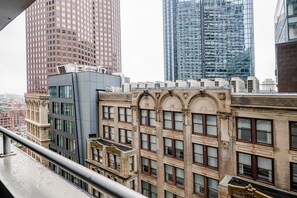 Un edifici de grans alçades amb una estructura de finestres en forma de quadrícula, una construcció de vidre moderna i un edifici clàssic amb detalls ornamentals.