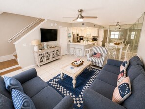 A modern living room with a sofa set, a coffee table, and a television.